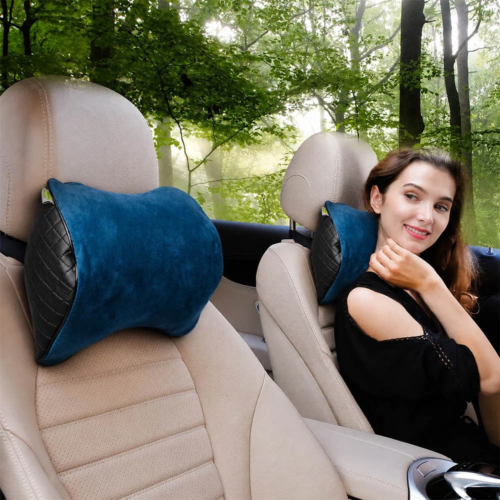 Woman in a car with a neck support pillow, hand resting on her neck